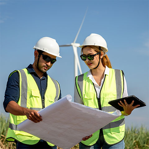 Engineers working in wind turbine farm background